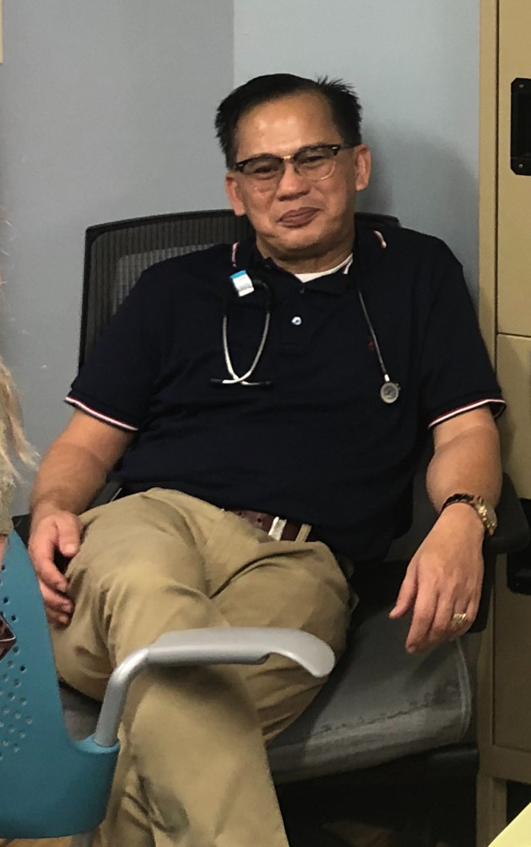 Dr. James Zozobrado sitting in a chair and smiling