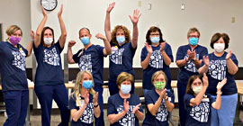 Employees wearing State-48 t-shirts clapping