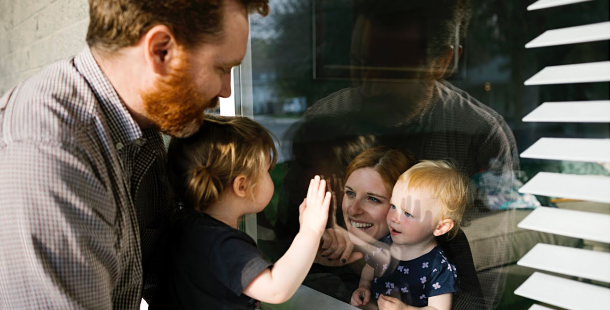 Parents with kids looking through window