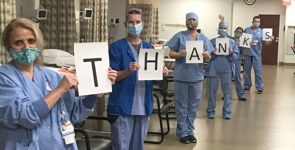 Employees holding thank you signs
