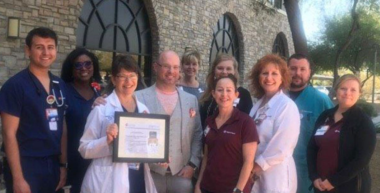 Employees holding a plaque